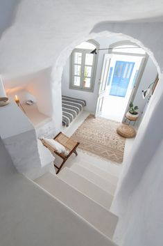 the interior of a house with white walls and stairs leading up to an open door