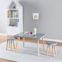 a child's table and two stools in a room