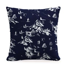 a blue pillow with white mountains and trees on the front, in black and white