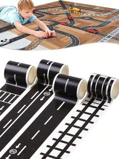 a child playing with toy cars and tracks on the floor next to a roll of tape