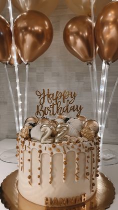 a birthday cake decorated with gold balloons and confetti