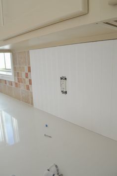 a kitchen with white cabinets and tile backsplash in the middle of it's remodel