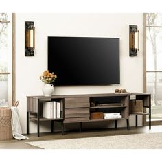 a large flat screen tv mounted to the side of a wooden entertainment center in a living room