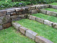 stone steps in the grass next to some bushes