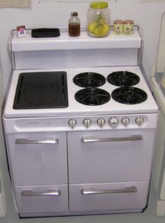 a white stove top oven sitting inside of a kitchen