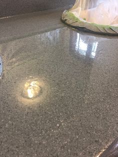 a close up of a counter top with a trash can in the background and garbage bag on the floor