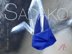 an origami paper airplane hanging from a string with the words sadako on it