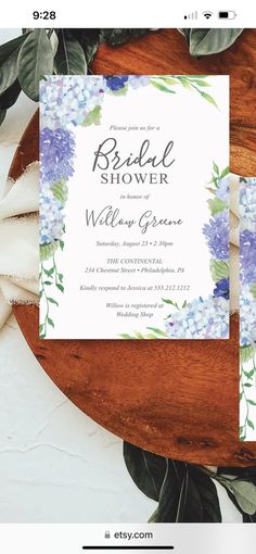 the bridal shower is displayed on top of a wooden table with flowers and greenery