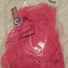 a pink bag filled with lots of plastic wrap and some tags on top of it