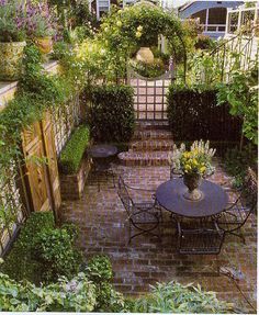 an outdoor dining area is shown in the middle of some plants and flowers on the ground