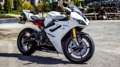 a white motorcycle parked on top of a parking lot next to a large city building