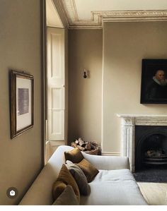 a living room filled with furniture and a fire place next to a painting on the wall