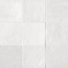 a white tile wall with several squares on it