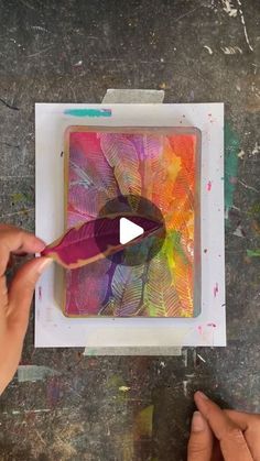 someone is painting leaves with acrylic paint on a piece of paper and then using scissors