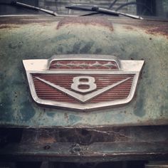 an old, rusty car with the number eight on it's front grills