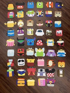 an assortment of cut out stickers sitting on top of a wooden table next to a cell phone