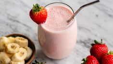 a smoothie with bananas and strawberries on the side