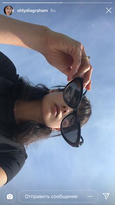 a woman wearing sunglasses looking up into the sky