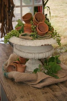 an arrangement of clay pots and plants on a table