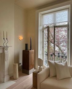 a living room filled with furniture and a fire place in front of a large window