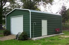 a green garage with a red chair in the yard