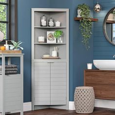 a bathroom with blue walls and wooden floors, white sink and cabinet in the corner