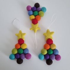 two felt christmas trees with balls and stars on them, one is multicolored