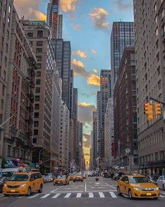 a city street filled with lots of traffic and tall buildings under a cloudy blue sky