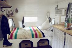 a small bedroom with a bed made out of an old bus's interior compartment