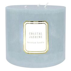 a blue candle with a white label on it that says coastal jasmine scented candle