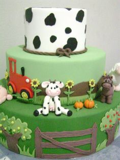 a three tiered cake decorated with farm animals and cows on it's side