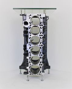 an engine block is shown on display in front of a white wall and glass table