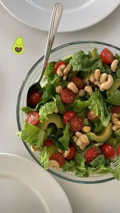 a salad with tomatoes, lettuce and cashews