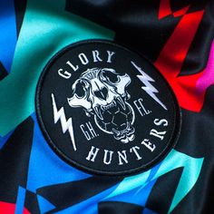 a patch on the back of a jacket that says glory to the hunters with an image of a skull and lightning