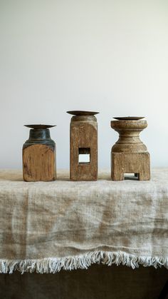 three wooden vases sitting on top of a table