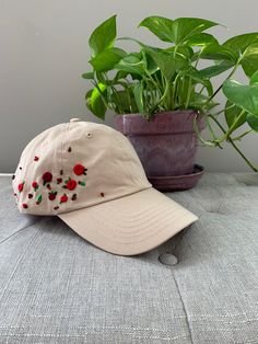 Run for the roses! Lovely red and burgundy roses adorn this beige cap. This listing is for one hand embroidered baseball cap.   Each of my PetalStitch baseball cap designs is unique and one of a kind.  They are inspired by the beautiful wildflowers we have here in Wisconsin in our backyards and in the countryside.  I'm constantly designing new caps, so please check back often to see new listings.  Hats are a cotton "one size fits most" and can be sized with the adjustable metal slider on the back.  If you have any specific questions regarding the hats, please reach out to me via Etsy messages. This hat is ready to ship and will ship free via USPS first class mail.  Priority mail is available as an upgrade at checkout.  Please note that you will be provided with a tracking number which you Cream Embroidered Hat With Curved Brim, Cream Curved Brim Embroidered Hat, Beige Embroidered Hat With Curved Brim, Embroidered Cream Cap, Cream Embroidered Cap, Adjustable Baseball Cap With Floral Embroidery, Adjustable Floral Embroidery Baseball Cap, Red Embroidered Baseball Cap With Curved Brim, Embroidered Pink Baseball Cap