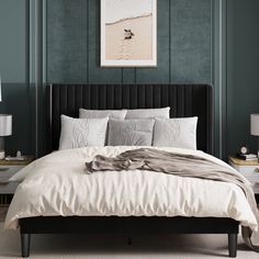 a bedroom with green walls and a black headboard, white bedding and pillows