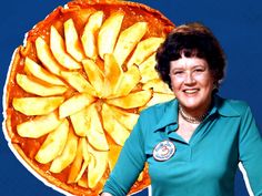 a woman standing next to a giant pizza with sliced apples on it's side