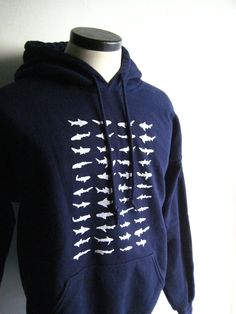 This sharky design features 44 unique sharks, hand printed using a silkscreen. The shirt is an adult navy blue Gildan brand poly/cotton hoodie with white sharks. Since these shirts are unisex, women may prefer to order one size smaller than their usual size. Shark Clothing, Shark Things, Shark Clothes, Shark Stuff, Shark Bait, Shark Hoodie, Fandom Fashion, Shark Week, White Sharks