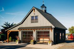 a garage with a clock on the top of it's roof and an attached parking lot