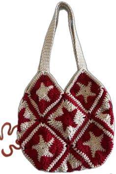 a crocheted red and white handbag hanging from a hook