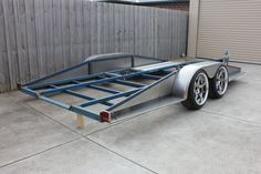 the trailer is parked in front of a garage door and has wheels on each side