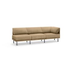 a beige couch sitting on top of a white floor next to a wooden frame and metal legs