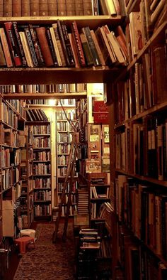 a library filled with lots of books next to a staircase leading up to the second floor