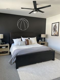 a bedroom with a bed, nightstands and pictures on the wall above it that has a basketball painted on the wall