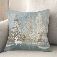 a decorative pillow with deer and trees on it