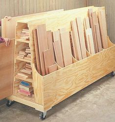 a man standing next to a large wooden box filled with wood planks on wheels