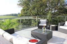 a balcony with wicker furniture and white cushions