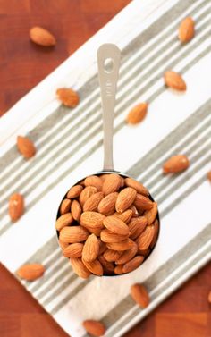 a spoon full of almonds sitting on top of a table