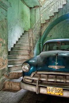 an old car parked in front of some stairs